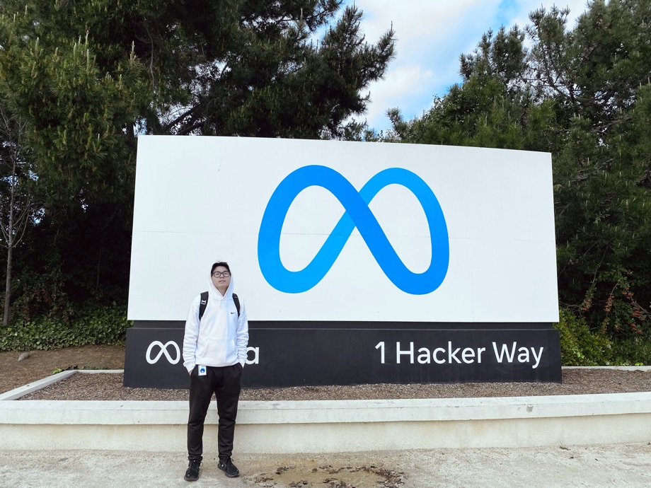 Standing in front of the Meta sign at 1 Hacker Way